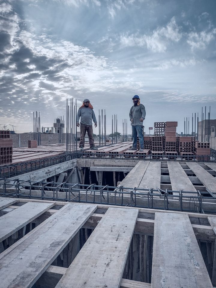 Construction workers on a reinforced deck at sunrise
